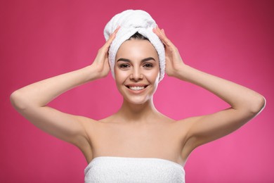 Photo of Happy young woman with towel on head against pink background. Washing hair
