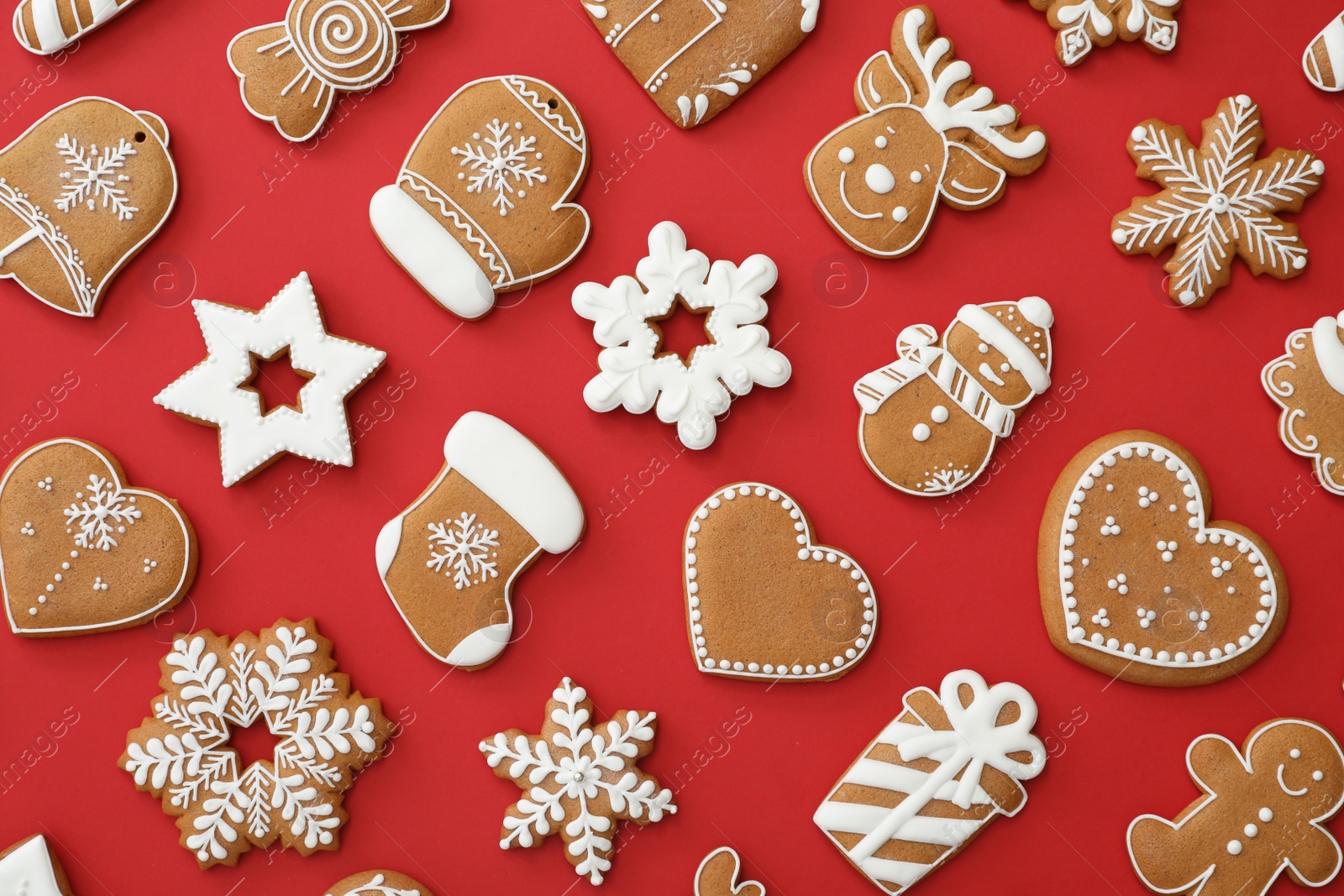 Photo of Different Christmas gingerbread cookies on red background, flat lay