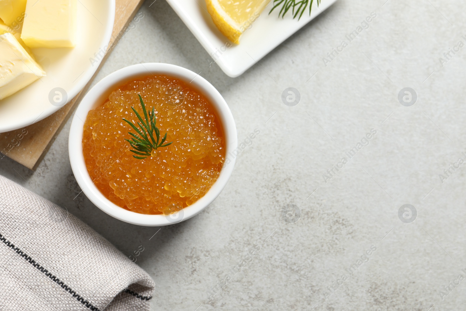 Photo of Fresh pike caviar, dill, butter and lemon on light grey table, top view. Space for text