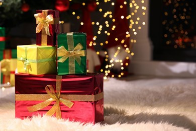 Photo of Beautiful Christmas gifts on furry carpet in room, space for text