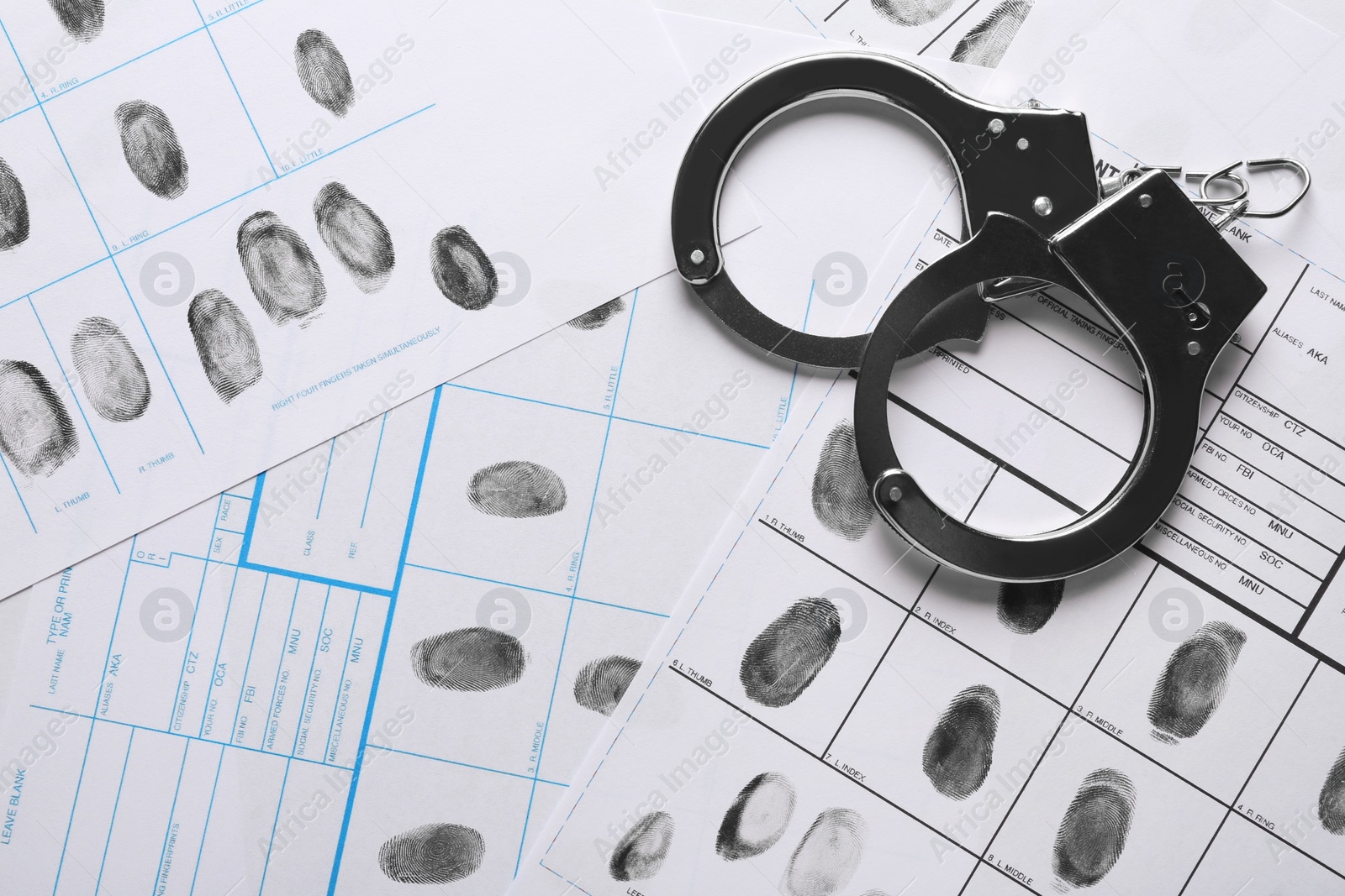 Photo of Handcuffs and fingerprint record sheets, top view. Criminal investigation