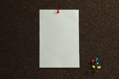 Photo of Blank paper sheet and pins on cork board