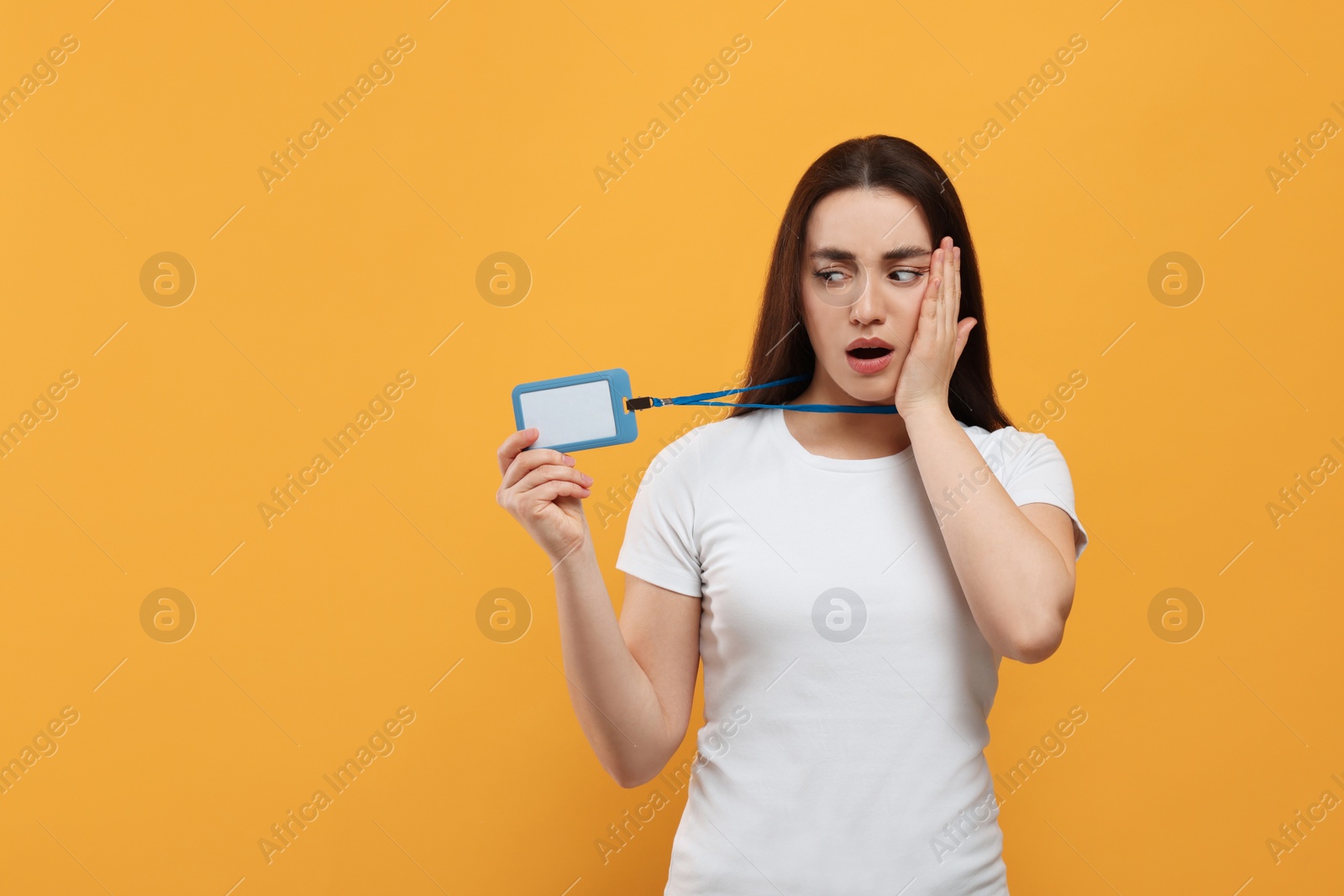 Photo of Worried woman with vip pass badge on orange background. Space for text