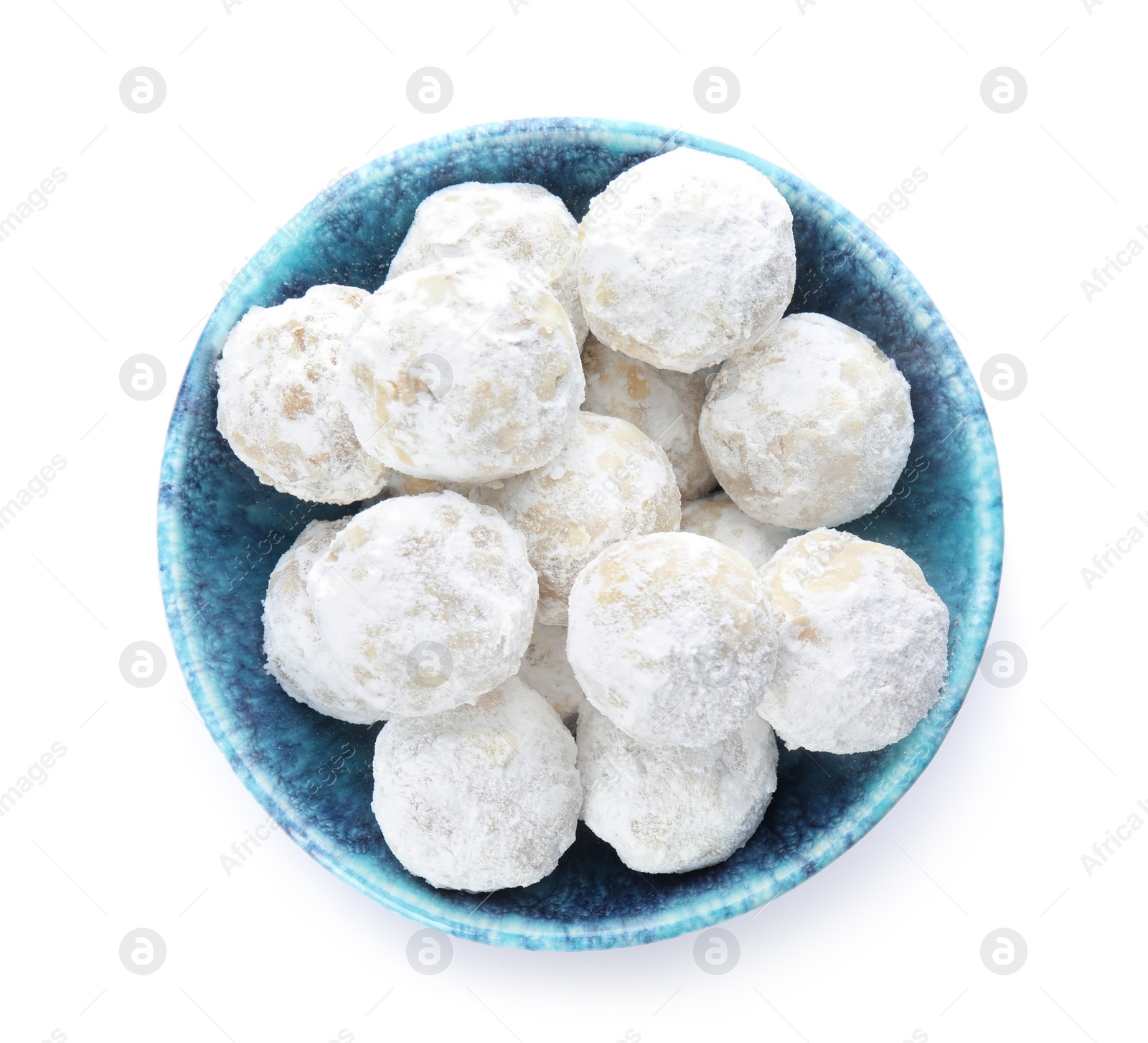 Photo of Tasty snowball cookies in bowl isolated on white, top view. Christmas treat