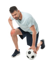 Full length portrait of soccer player with ball having knee problems on white background