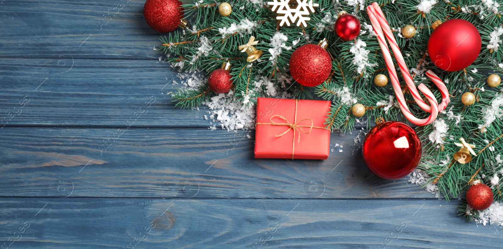 Photo of Fir tree branches with Christmas decoration on blue wooden background, flat lay. Space for text