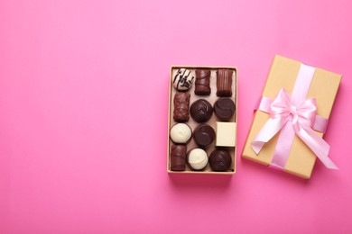 Photo of Open box with delicious chocolate candies on pink background, top view. Space for text