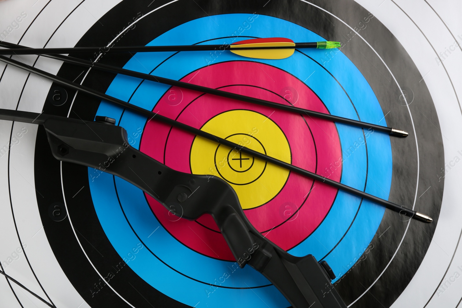 Photo of Arrows and bow on archery target, top view