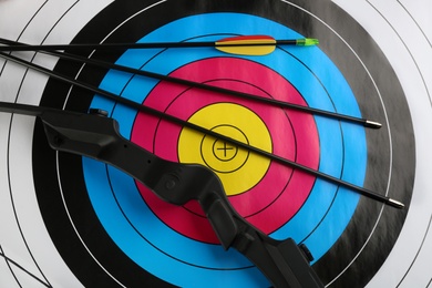 Arrows and bow on archery target, top view