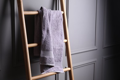 Photo of Terry towel on wooden ladder indoors, space for text