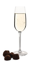 Photo of Glassdelicious sparkling wine and chocolate truffles isolated on white