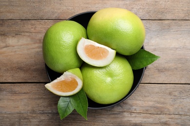 Photo of Fresh ripe sweetie fruits on wooden table, top view