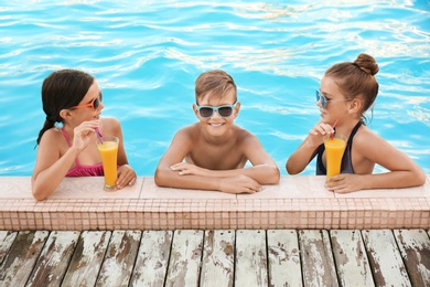 Photo of Happy children with drinks in swimming pool