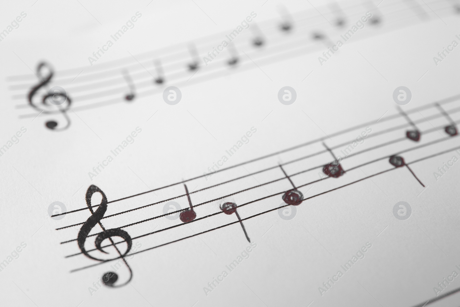 Photo of Sheet of paper with music notes as background, closeup view