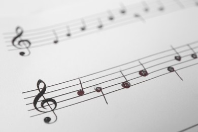 Photo of Sheet of paper with music notes as background, closeup view