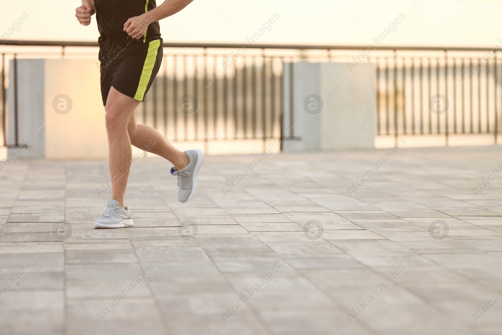 Photo of Young man running outdoors on sunny day