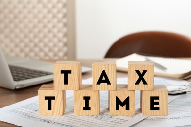 Wooden cubes and documents on table indoors. Tax time