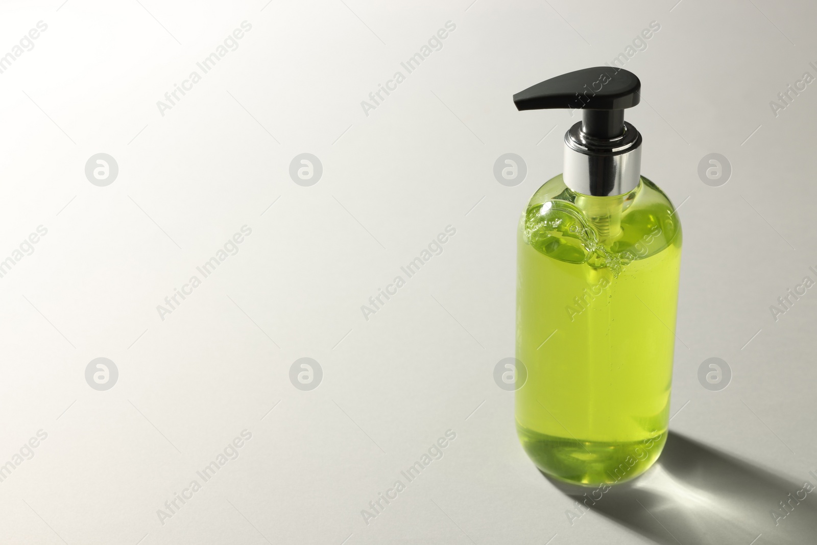 Photo of Bottle of liquid soap on grey background. Space for text