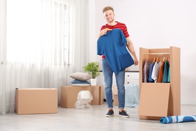 Young man near wardrobe box at home