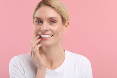 Woman with clean teeth smiling on pink background, space for text