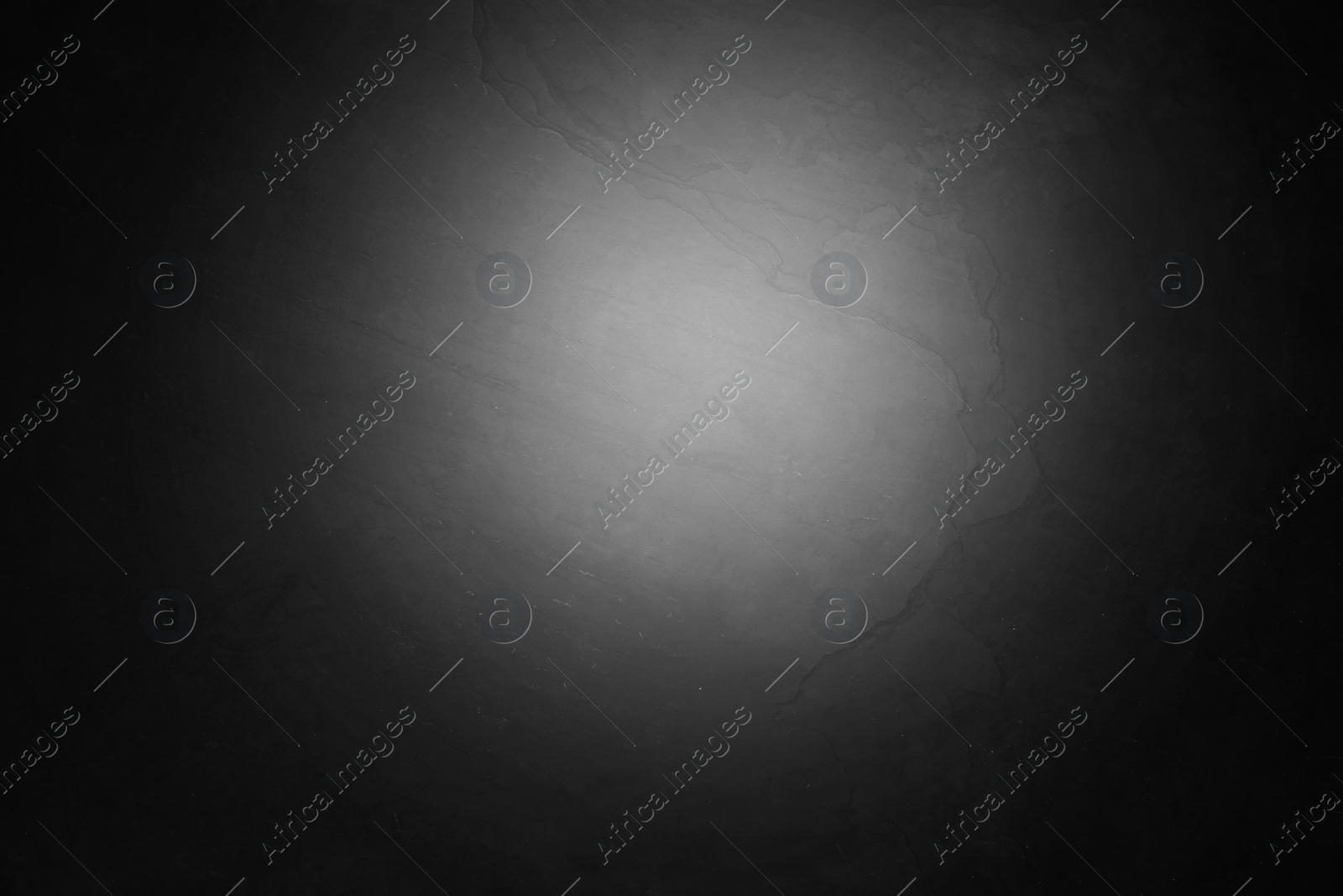 Image of Black slate surface with spot of light as background, top view