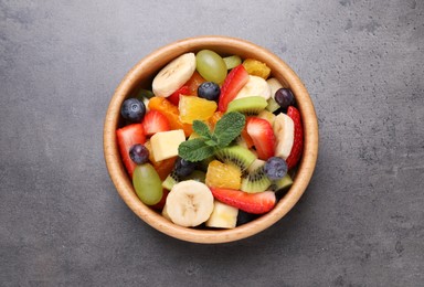 Delicious fruit salad on grey table, top view