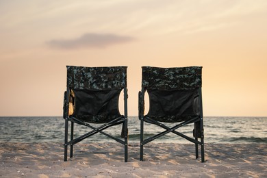 Photo of Camping chairs on sandy beach near sea