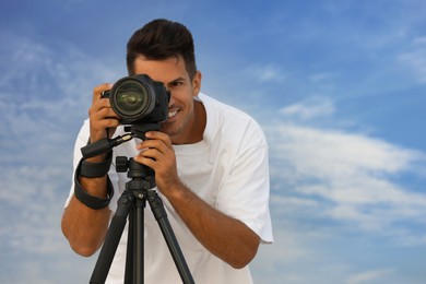 Photographer taking picture with professional camera outdoors