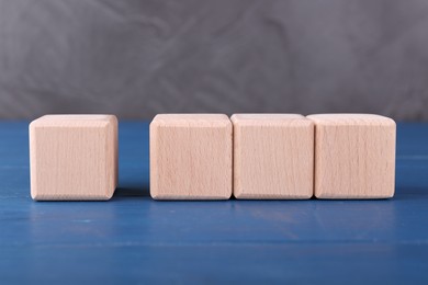 Photo of International Organization for Standardization. Cubes with check mark and abbreviation ISO on blue wooden table