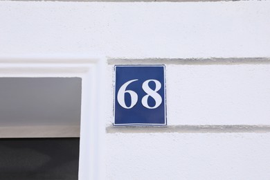 Photo of Plate with house number sixty eight on white building outdoors
