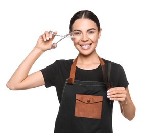 Photo of Portrait of happy hairdresser with professional scissors and combs on white background