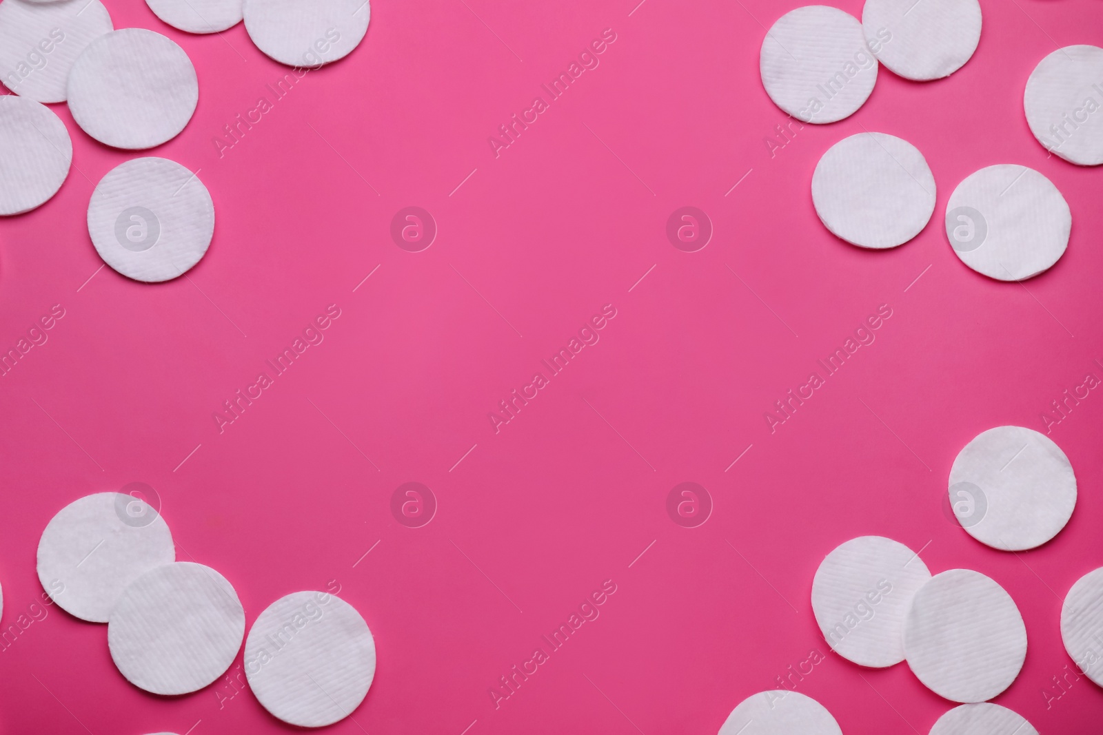 Photo of Clean cotton pads on pink background, flat lay. Space for text