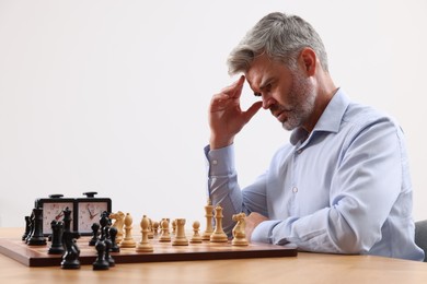 Photo of Man playing chess during tournament at table against white background