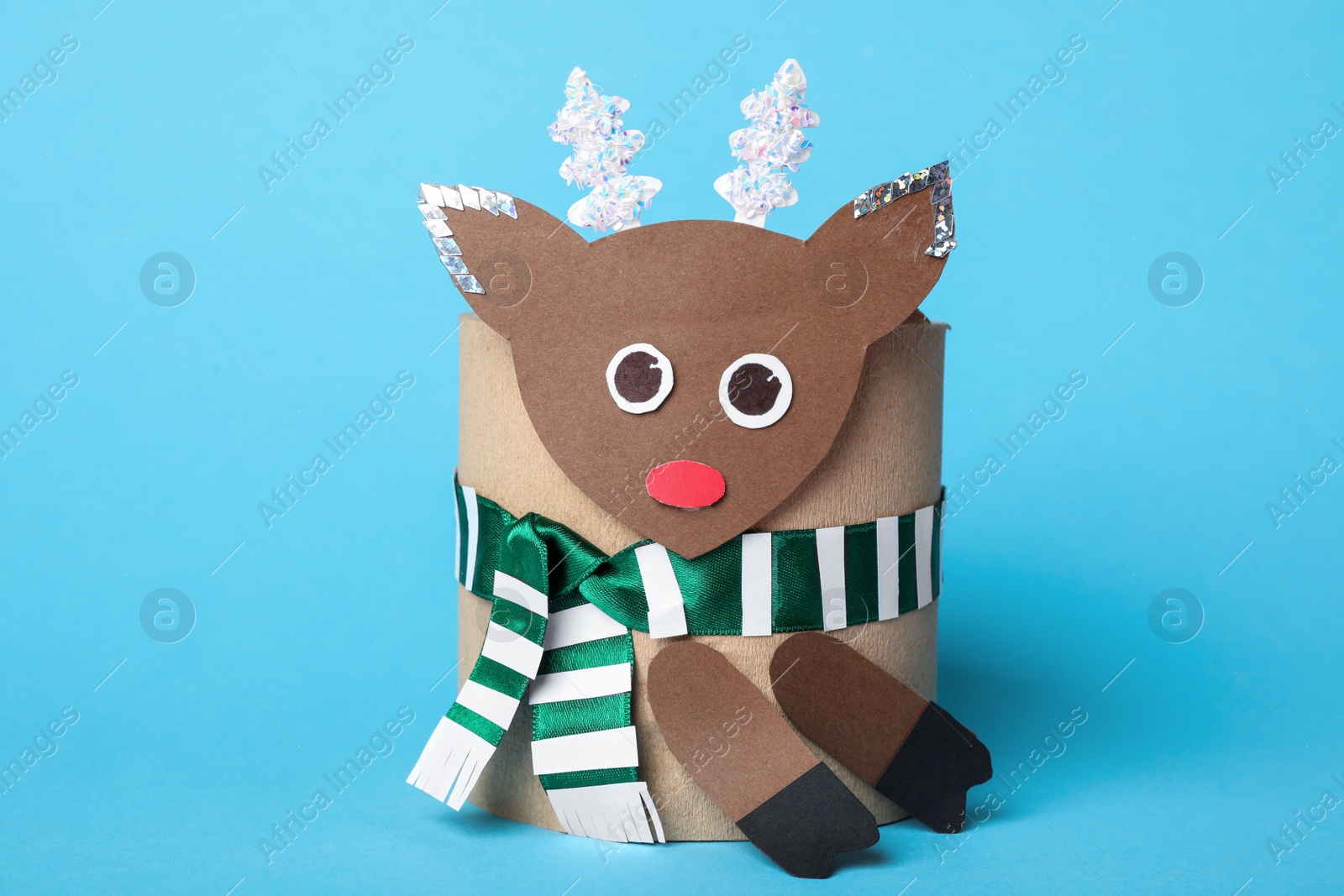 Photo of Toy deer made of toilet paper roll on light blue background