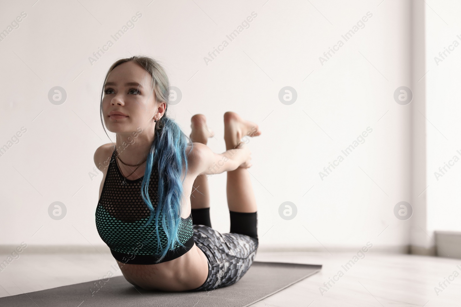 Photo of Young woman practicing yoga indoors