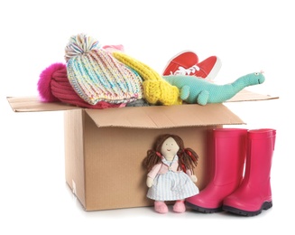 Photo of Donation box, shoes, clothes and toys on white background