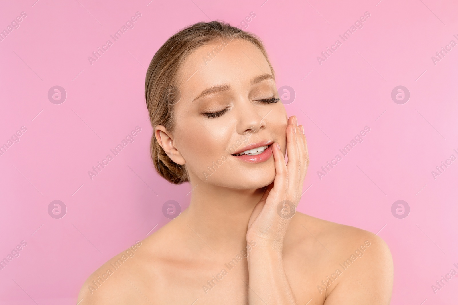 Photo of Portrait of young woman with beautiful face on pink background