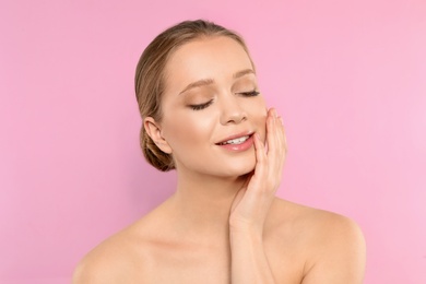 Portrait of young woman with beautiful face on pink background