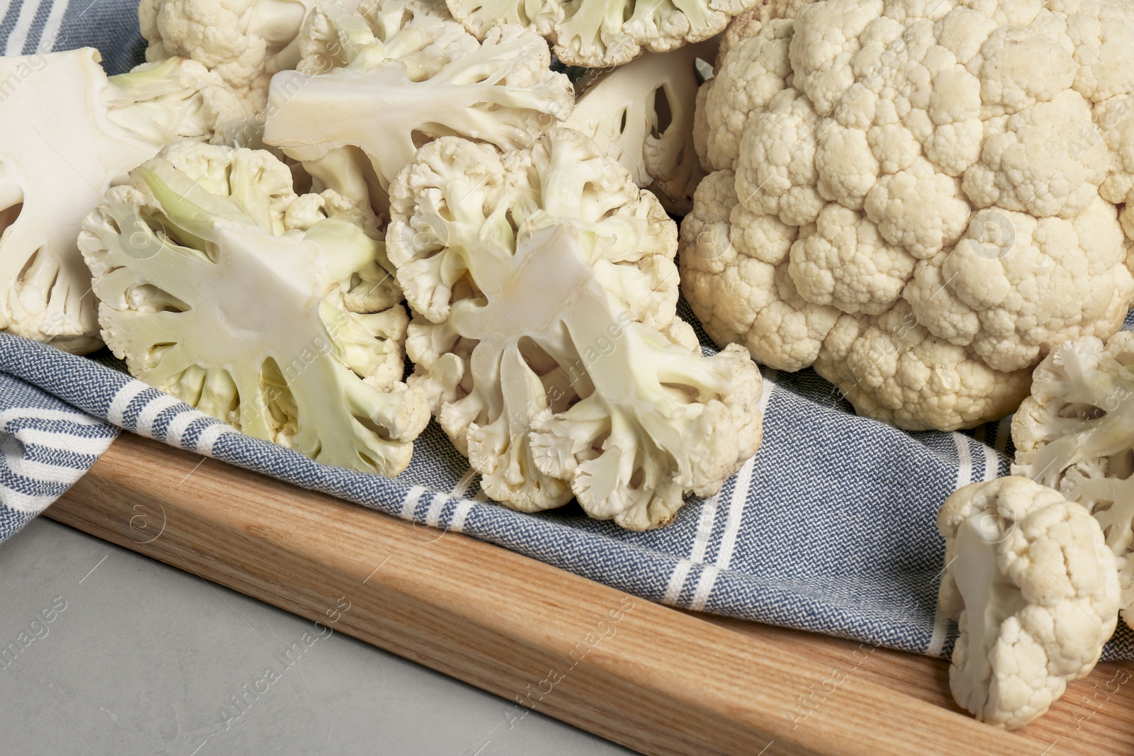 Photo of Fresh raw cauliflower on light grey table, closeup