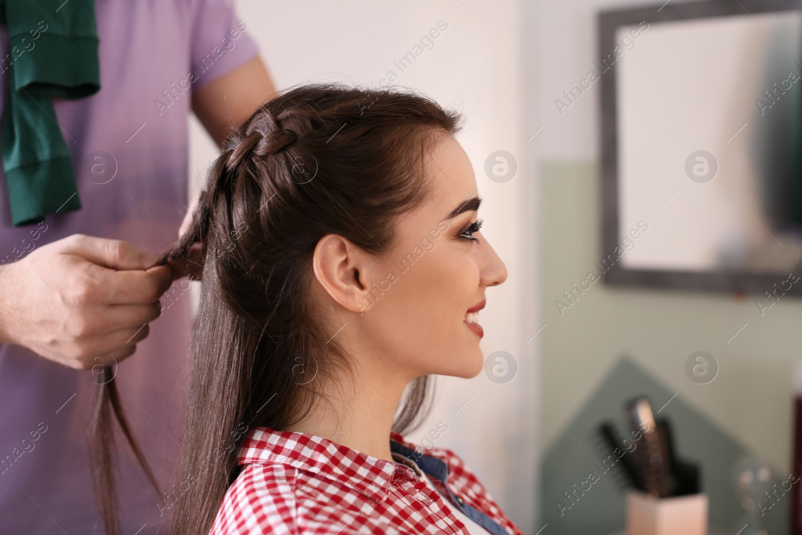 Photo of Professional hairdresser working with client in beauty salon