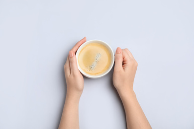 Photo of Woman with cup of coffee on white background, top view