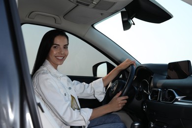 Photo of Beautiful young woman on driver's seat in modern car