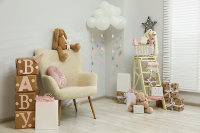 Photo of Baby shower party. Festive decor, gift boxes and toys in stylish room