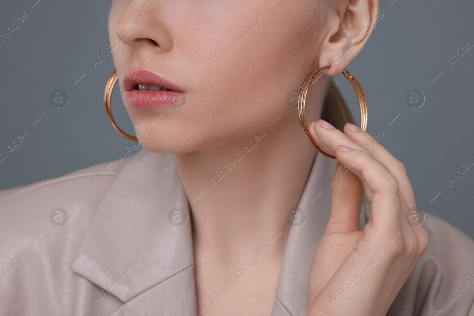 Photo of Woman with elegant earrings on gray background, closeup