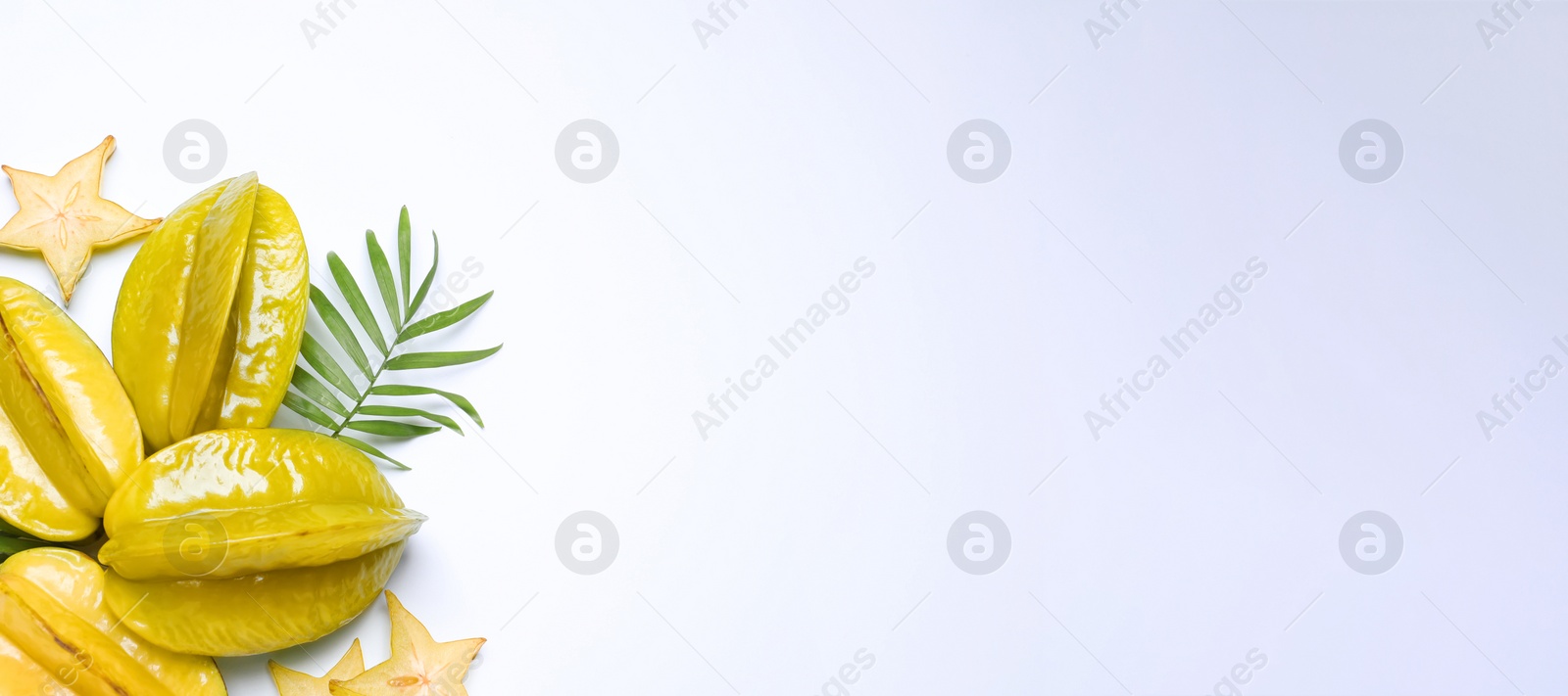 Photo of Delicious carambola fruits and leaves on white background, flat lay