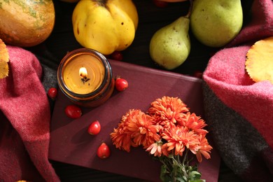 Photo of Autumn flat lay composition with beautiful orange chrysanthemum flowers, scented candle and rosehip berries on wooden table