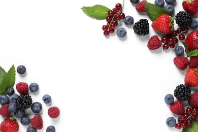 Many different fresh berries and mint leaves on white background, flat lay. Space for text