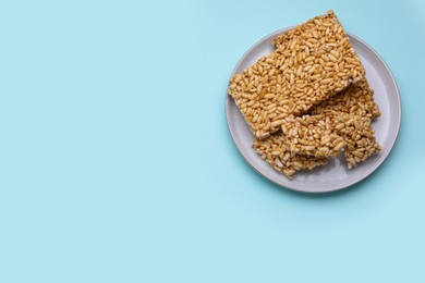 Puffed rice bars (kozinaki) on light blue background, top view. Space for text