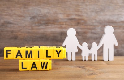 Image of Cubes with letters and family figure on wooden table. Family law concept