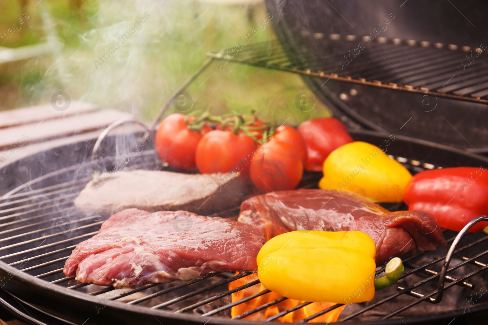 Photo of Modern grill with meat and vegetables outdoors, closeup